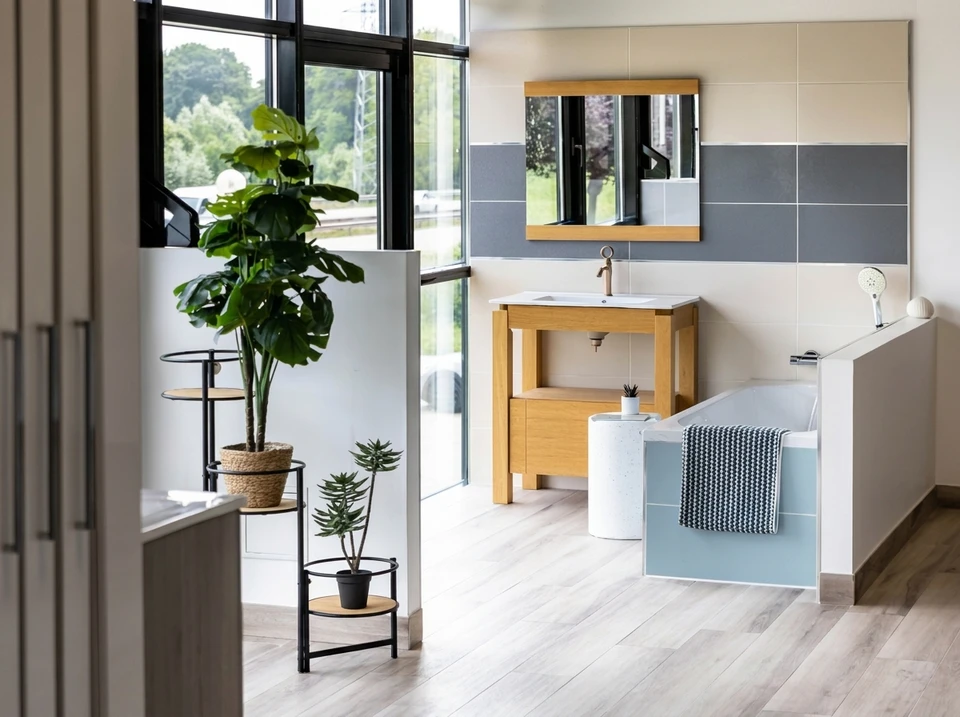 Cuisine moderne ouverte avec îlot central, plan de travail blanc, façades en bois clair et éléments hauts noirs